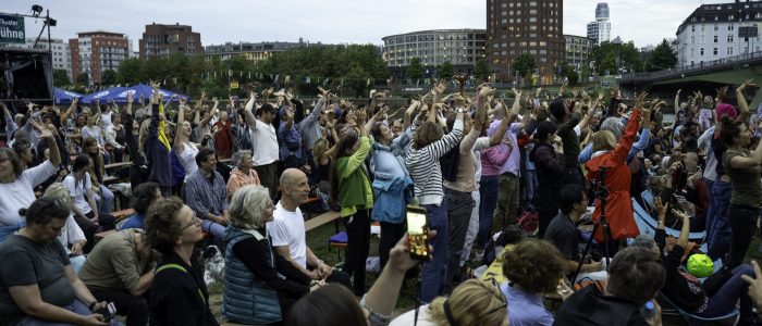 Ca. 100 Menschen unterschiedlichen Alters und Geschlechts recken die Arme zum Himmel und tanzen. Das Publikum von I*ON bei der Night of Dance hat mitgetanzt.